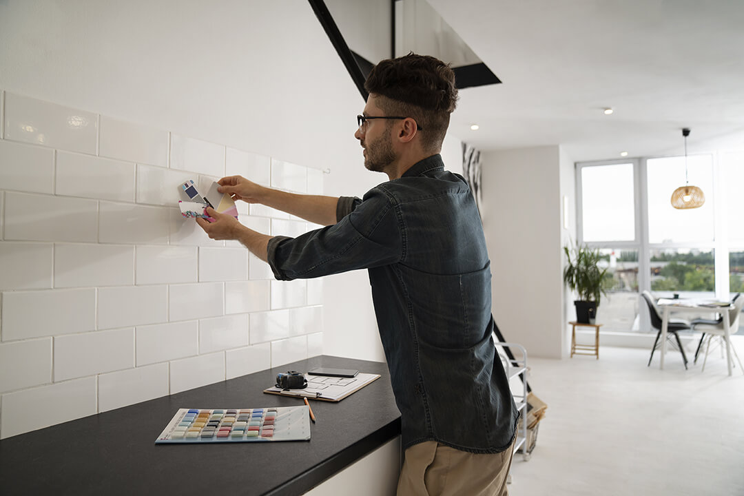Side view of a man with colour swatches planning a kitchen renovation.